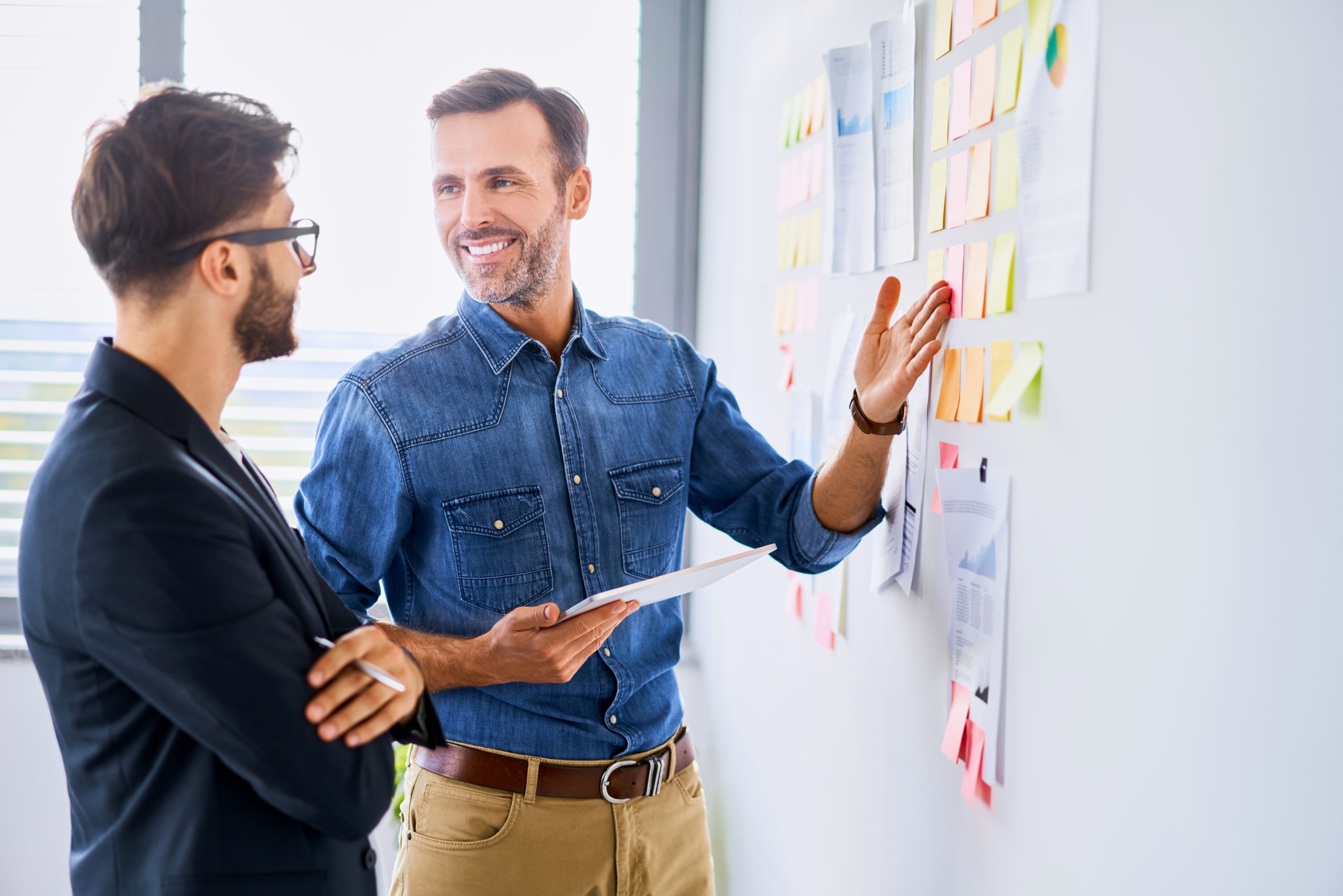 Creative worker and businessman smiling and talking in modern office